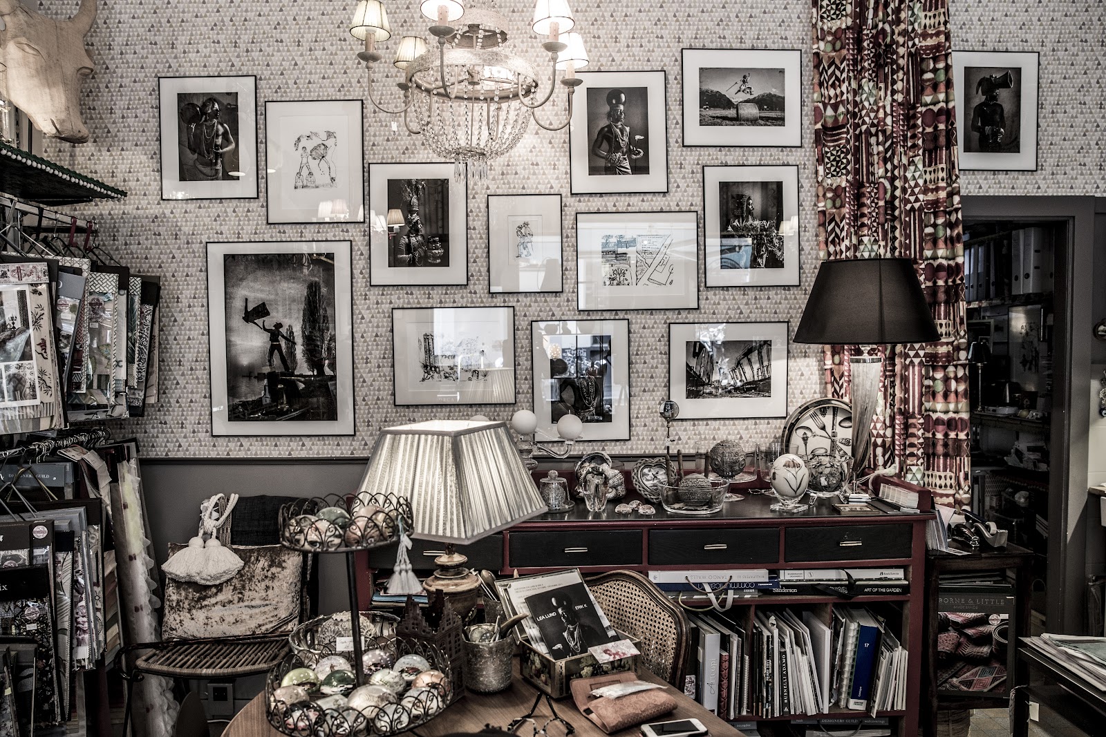 Intérieur de la boutique Pièces à Conviction — galerie de cadres, lustre, papier peint et objets de décoration