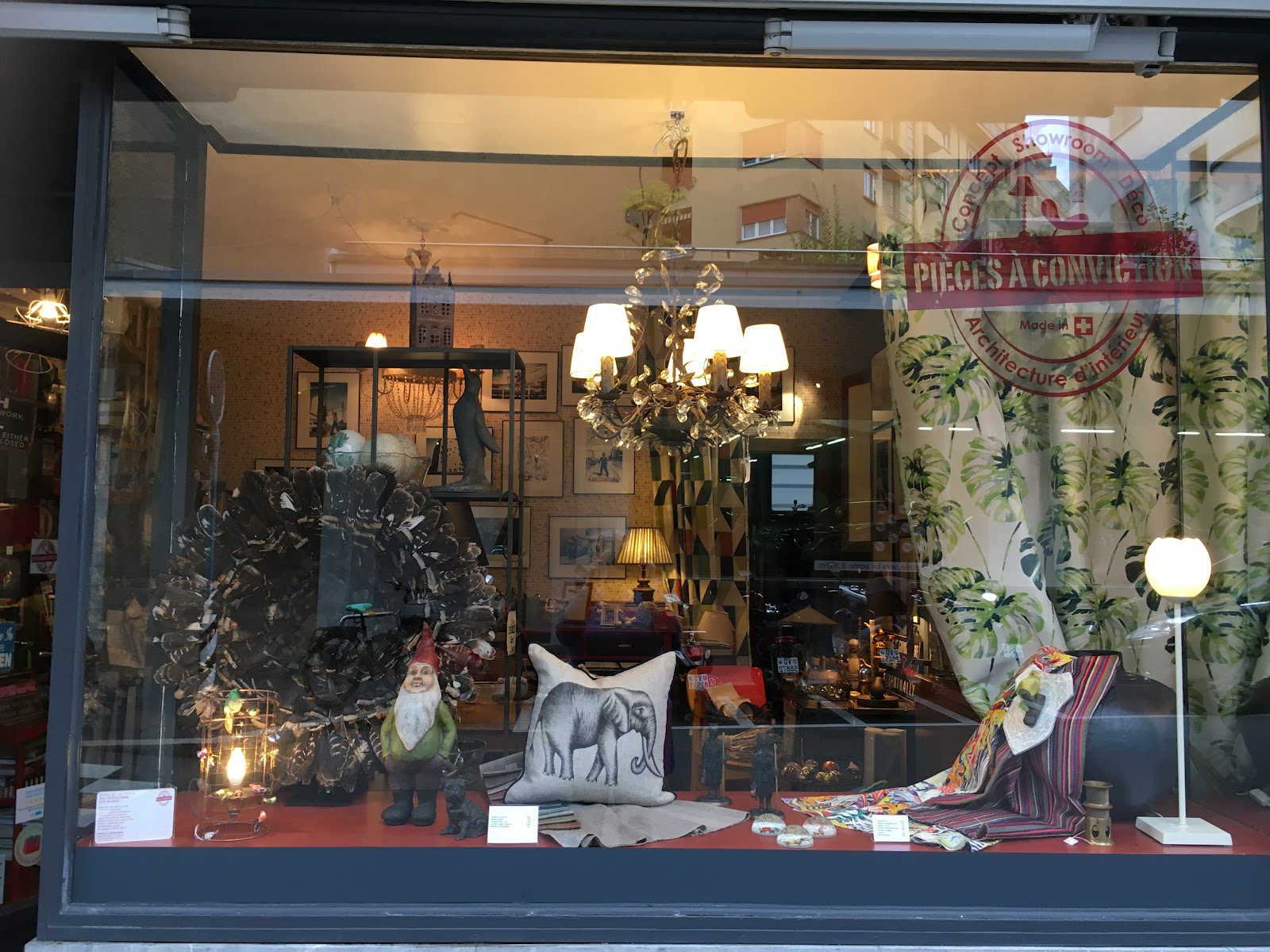 Vitrine de la boutique — lustre doré, textiles colorés et objets chinés