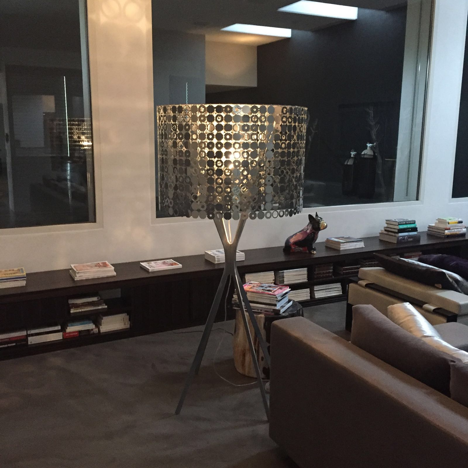 Salon contemporain avec lampe design ajourée et bibliothèque